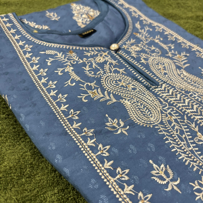 Blue fabric with gold embroidery on a green surface