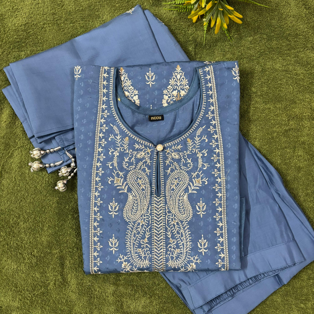 Blue embroidered outfit on a green background